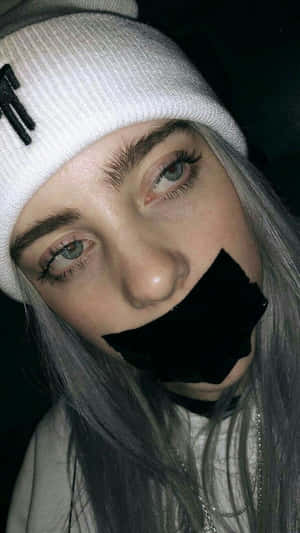 Billie Eilish Sad Expression With Tape Over Mouth Wallpaper