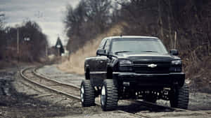 Black Lifted Truck On Railroad Track Wallpaper