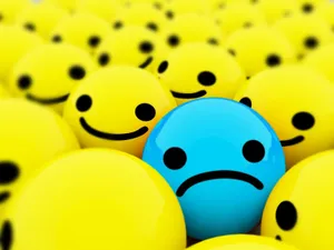Blue Sad Emoji Among Smileys Wallpaper