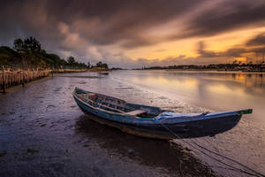 Boat Docked Along The Riverside Wallpaper