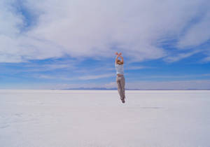 Bolivia Girl Jumping On Salt Plains Wallpaper