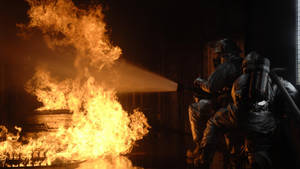 Braving The Flames: Firefighter In Action Wallpaper