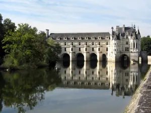 Breathtaking View Of Chenonceau Castle Amidst Riverside Vegetation Wallpaper