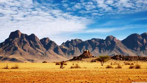 Breathtaking View Of The Desert Surrounded By High Mountains Wallpaper