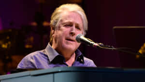 Brian Wilson Of The Beach Boys Engaging The Crowd At A 2017 Concert Wallpaper