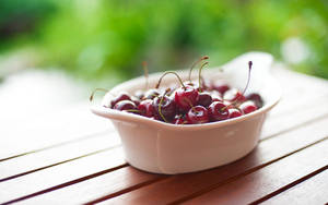 Bright Red Cranberries In A Ceramic Bowl Wallpaper