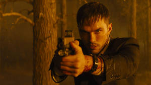 British Actor Nicholas Hoult Holding A Gun Wallpaper