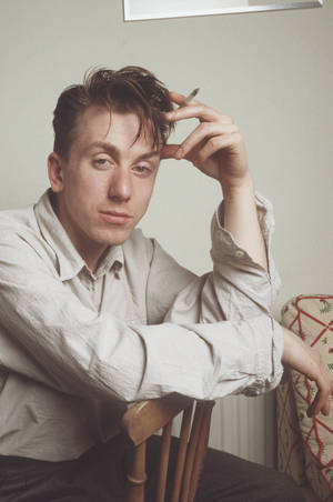 British Talent: A Portrait Of Young Tim Roth Smoking On Chair Wallpaper