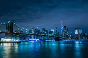 Brooklyn Bridge At Night With The City Lights Wallpaper