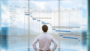 Businessman Staring At Holographic Project Management Schedule Wallpaper