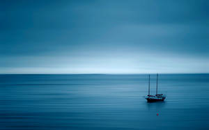 Calming Boat At Blue Sea Wallpaper