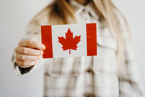 Canadian Flag Held By Woman Wallpaper