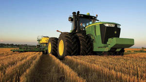 Caption: A Pristine John Deere 9r Series Tractor Standing Tall In A Grand Landscape. Wallpaper