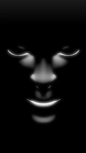 Caption: Black Horror Face Mask Illuminated In Darkness Wallpaper