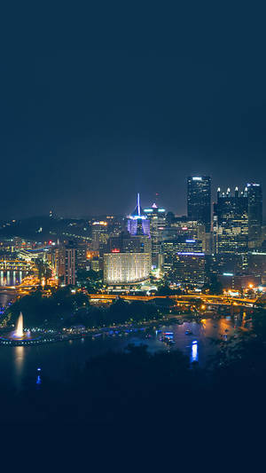 Caption: Cityscape Of Pittsburgh At Sunset Wallpaper