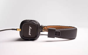 Caption: Classic Marshall Headphones On A Crisp White Surface Wallpaper