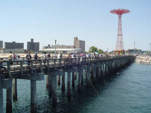 Caption: Coney Island's Iconic Parachute Pier Against A Sunset Sky Wallpaper