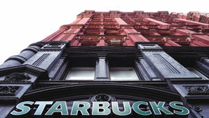 Caption: Majestic Starbucks Tower Dominating The City Skyline Wallpaper