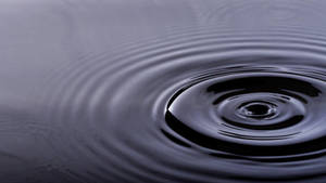 Caption: Mysterious Rippling Water Surface Wallpaper