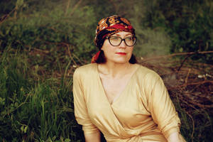 Caption: Older Woman In A Bandanna Radiating Wisdom And Vitality Wallpaper