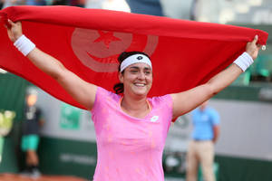 Caption: Ons Jabeur Holds High The Tunisian Flag In Celebration Wallpaper