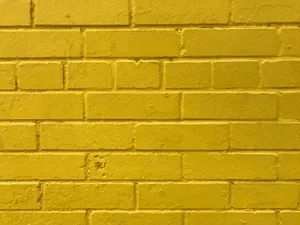 Caption: Radiant Golden Brick Wall Wallpaper