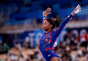 Caption: Simone Biles Impressively Executing A Floor Routine. Wallpaper