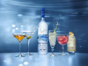 Caption: Sophisticated Enjoyment – Grey Goose Vodka Bottle With Crafted Cocktails Wallpaper