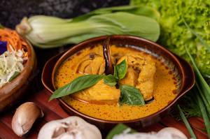 Caption: Vibrant And Spicy Red Thai Curry With Vegetables Wallpaper