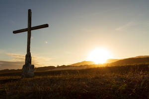 Captivating Cross Under Warm Sunset Wallpaper