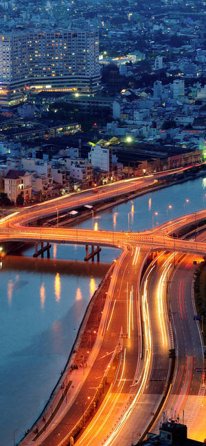 Captivating Ho Chi Minh City At Night With Bustling Traffic Wallpaper