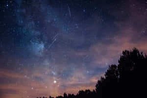 Captivating Meteor Shower In A Starry Night Sky Wallpaper