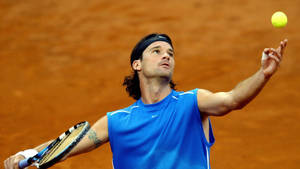 Carlos Moya Expertly Delivering A Tennis Serve Wallpaper