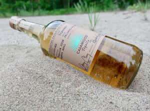 Casamigos Tequila Reposado Liquor Bottle On Sand Wallpaper