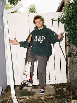 Casual Musicianwith Guitar Outdoors Wallpaper