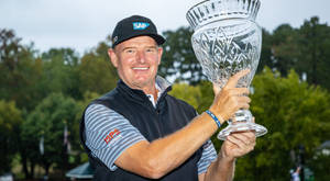 Champion Golfer Ernie Els Holding A Glass Trophy Wallpaper