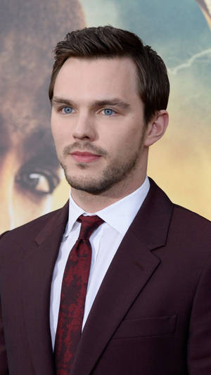 Chic Nicholas Hoult Dressed In A Classy Maroon Suit Wallpaper