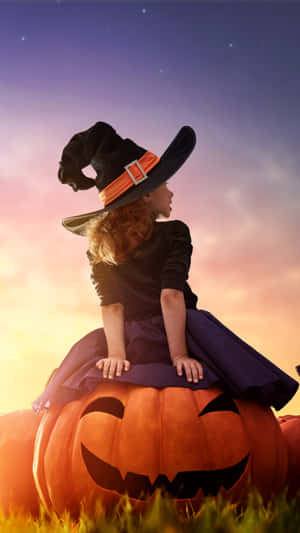 Child Witch Sittingon Jack O Lanternat Dusk Wallpaper