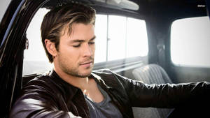 Chris Hemsworth Driving In A Luxurious Car Wallpaper