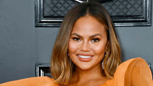 Chrissy Teigen Orange Dress Smile Wallpaper