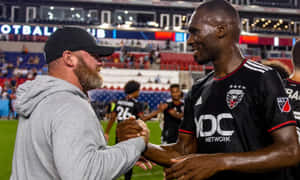Christian Benteke Shaking Hands With Wayne Rooney Wallpaper