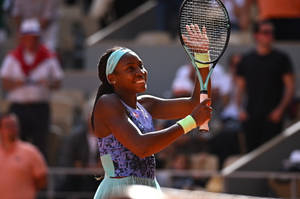 Coco Gauff Raising Her Tennis Racket Wallpaper