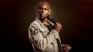 Comedian Dave Chappelle Performing On Stage Wallpaper