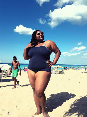 Confident Plus-sized Black Woman In Swimsuit Wallpaper