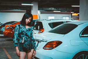 Confident Woman Posing In A Spacious Parking Lot Wallpaper