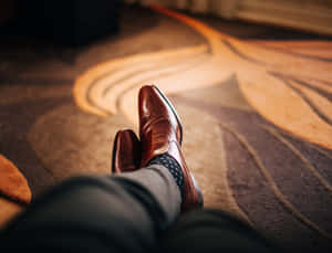 Contemporary Male Feet In Brown Leather Shoes. Wallpaper