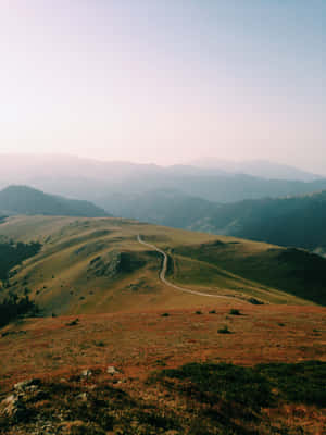 Country Road Between Brown And Green Hills Wallpaper