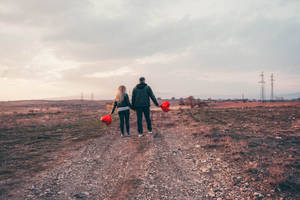 Couple Carrying Cute Heart Balloons Wallpaper