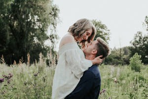 Couple Hugging Catcher Hug Position At Outdoor Field Wallpaper