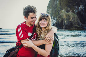 Couple Hugging Side By Side On The Beach Wallpaper